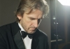 Pianist Barry Douglas sits at a piano, wearing a black suit and a black bow tie. Pianist Barry Douglas sits at a piano, wearing a black suit and a black bow tie.