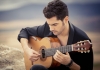 Miloš Karadaglić sits on a rock, playing guitar. Miloš Karadaglić sits on a rock, playing guitar.
