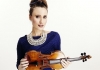 Violinist Jennifer Pike holds her violin, wearing a blue dress and beaded necklace. Violinist Jennifer Pike holds her violin, wearing a blue dress and beaded necklace.
