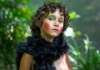a young girl with vivid green eye shadow and pink blush looks directly into the camera a young girl with vivid green eye shadow and pink blush looks directly into the camera