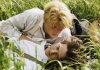 Two young men wearing white shirts and braces lie affectionately together in some long grass Two young men wearing white shirts and braces lie affectionately together in some long grass