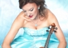Tasmin Little wears a blue ball gown and holds her violin. Tasmin Little wears a blue ball gown and holds her violin.