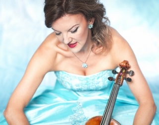 Tasmin Little wears a blue ball gown and holds her violin. Tasmin Little wears a blue ball gown and holds her violin.