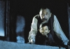 A young boy and an old man look down from a balcony. A young boy and an old man look down from a balcony.