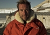 Ben Fogle, a man with blonde hair, stands in the snow wearing a large red parka Ben Fogle, a man with blonde hair, stands in the snow wearing a large red parka