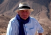 Dan Cruickshank sits in front of mountains, wearing a blue shirt and a straw hat Dan Cruickshank sits in front of mountains, wearing a blue shirt and a straw hat