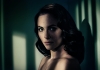 A brunette woman looks towards us, a shadow falling across her face A brunette woman looks towards us, a shadow falling across her face