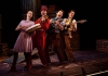 Four performers in colourful outfits sing and play their instruments. Four performers in colourful outfits sing and play their instruments.
